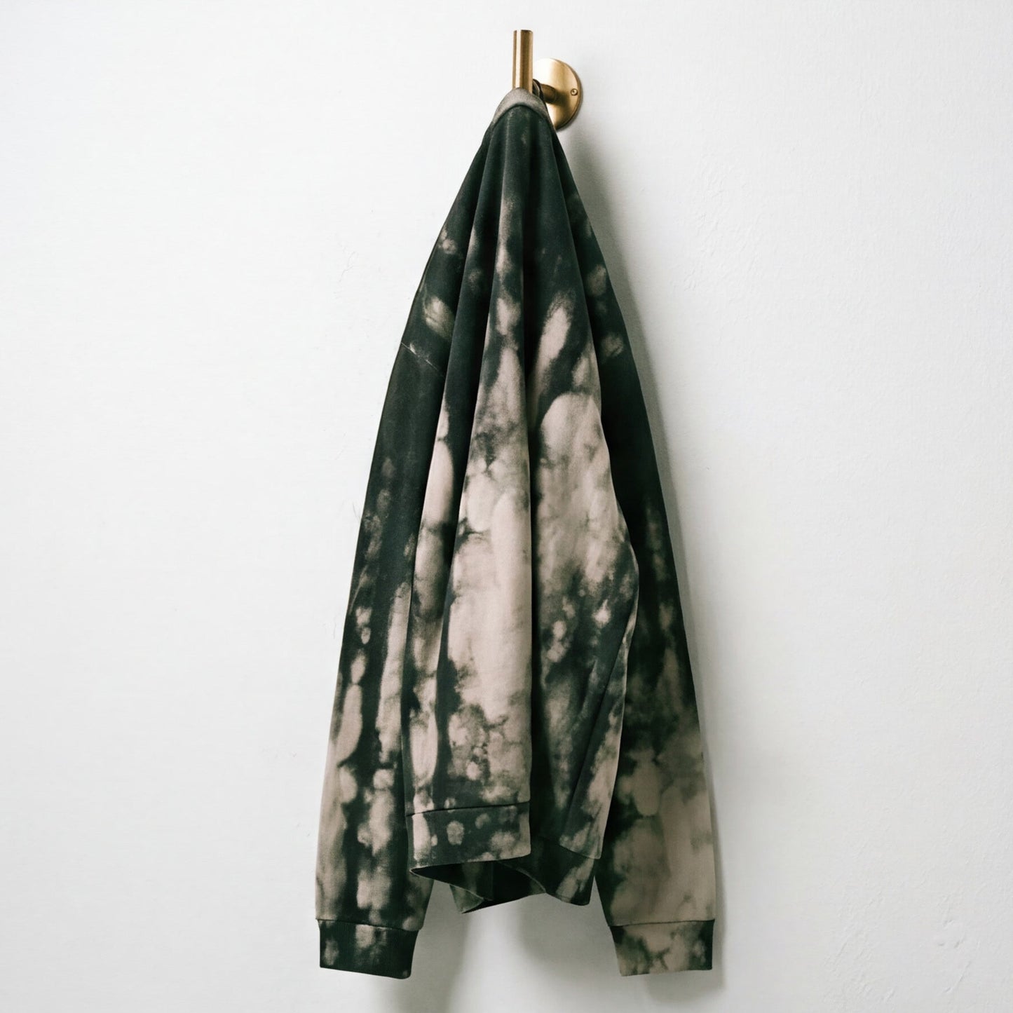 Fayah organic cotton sweatshirt displayed on a hanger, folded, and hanging against a white background.